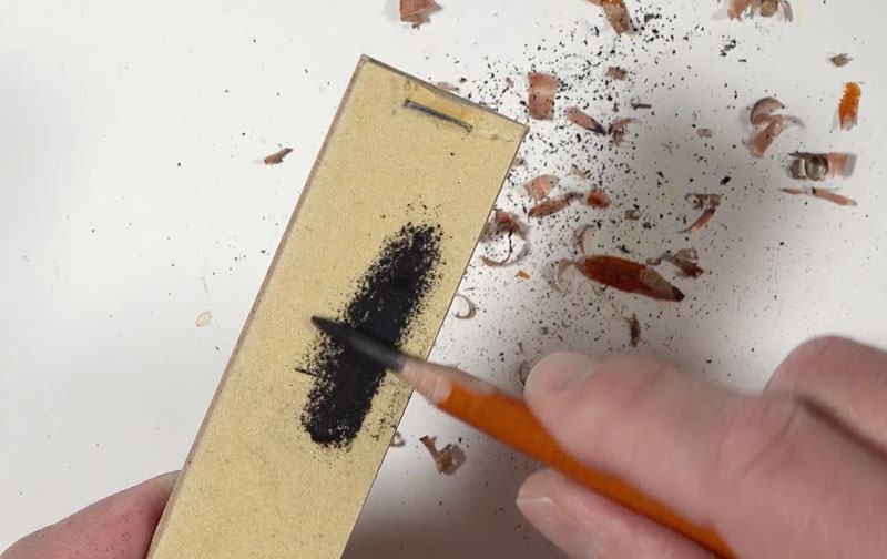 Using a sandpaper pad to sharpen pencil